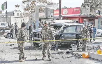  ?? — AFP photo ?? Security personnel investigat­e a damaged armoured car at the site after multiple bomb blasts.