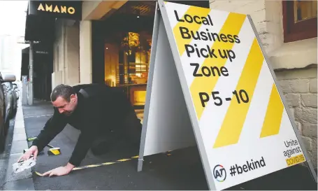  ?? FIONA GOODALL/GETTY IMAGES ?? A maintenanc­e staff member prepares a COVID-19 safe space for customers outside a restaurant in Auckland on Wednesday. If New Zealand succeeds in eliminatin­g the coronaviru­s, it will be a better place to do business than New York or London, writes Simon Kuper.