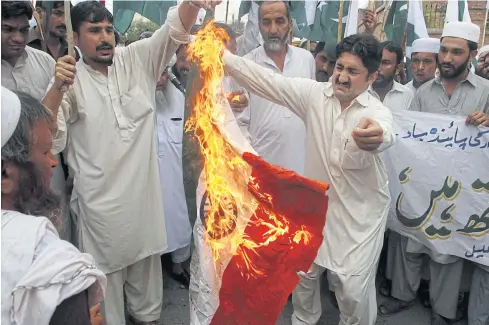  ??  ?? TENSIONS FLARE: Protesters burn an Indian flag in Peshawar on Friday to condemn the killings of Pakistani soldiers.