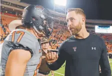  ?? Brody Schmidt, The Associated Press ?? Texas Tech coach Kliff Kingsbury, chatting with Oklahoma State wide receiver Dillon Stoner after a game this year, has built a reputation as a quarterbac­ks guru.