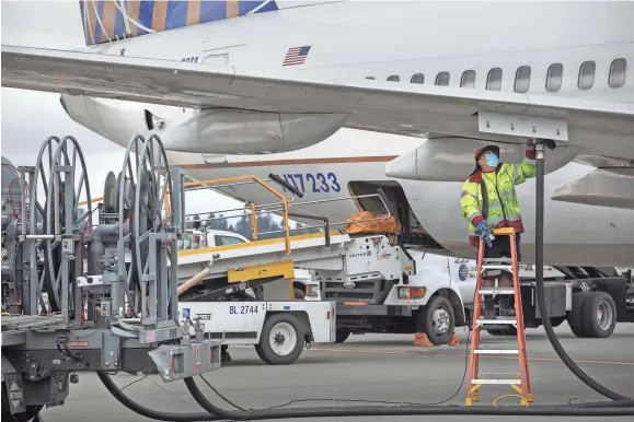  ?? ELLEN M. BANNER/THE SEATTLE TIMES VIA TNS ?? A plane is refueled on the tarmac at Seattle-tacoma Internatio­nal Airport in Seatac by a fueler Oct. 14 in Washington.