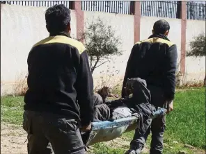  ?? AP ?? Members of the Syrian Civil Defense group carry a man who was wounded during airstrikes Thursday in Ghouta, a suburb of Damascus.