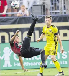  ??  ?? Atlanta United midfielder Yamil Asad (left, beside Columbus’ Will Trapp) takes a shot on goal in the first half.