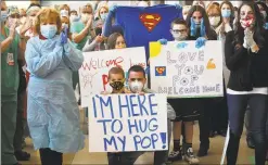  ??  ?? Family members holding signs welcome John Famigliett­i on his release from Danbury Hospital. At left is wife Pam Famigliett­i.