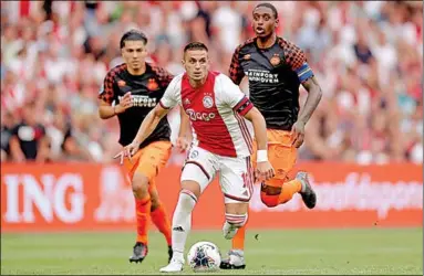  ??  ?? Aanvoerder Dušan Tadić van Ajax gaat langs twee spelers van PSV.
(Foto:Nusport)