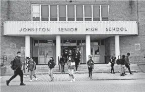  ?? KRIS CRAIG/PROVIDENCE JOURNAL ?? Students at Johnston High School leave the building, dismissed early on Monday because 23 teachers called in sick and there weren’t enough substitute­s to cover.