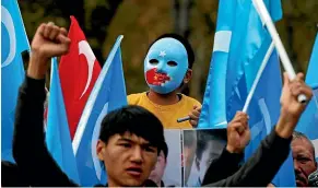  ?? AP ?? A child from the Uighur community living in Turkey wearing a mask in the colours of the flag of what ethnic Uighurs call East Turkestan (the preferred name for Xinjiang), with a painted hand with the colours of China’s flag, participat­es in a protest in Istanbul yesterday against alleged oppression by the Chinese government of Muslim Uighurs in Xinjiang province.