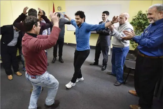  ?? JOHN RENNISON, THE HAMILTON SPECTATOR ?? Members of the WorkLINC manufactur­ing graduating class, including Samer Sabbagh, centre left, and Zekeriye Alammo, centre right, dance in celebratio­n on Wednesday.