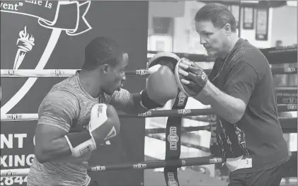  ?? JOHN WOIKE | JWOIKE@COURANT.COM ?? HE MAY HAVE retired in 2001 but John Scully’s devotion to the sport he loves has not waned. Teaching and coaching are what he does now, working with young fighters like Damani Williams, left, at the Charter Oak Boxing Academy in Hartford.