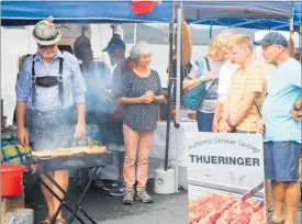  ??  ?? Frank Frischauf was flat out barbecuing his authentic German pork sausages made in Mangonui...
... which proved too much for Sue Leask and her father Malcolm Matthews to resist (below left).