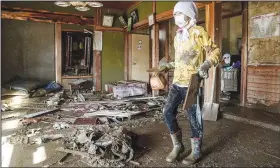  ?? AP/Kyodo News/KOKI SENGOKU ?? A boy cleans a house devastated by Typhoon Hagibis, in Nagano, central Japan, on Wednesday.