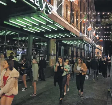  ?? PHOTO AFP ?? Hier soir, des piétons circulaien­t au centre-ville de Liverpool, au Royaume-Uni, avant l’imposition des nouvelles fermetures, annoncées lundi, dans plusieurs villes.