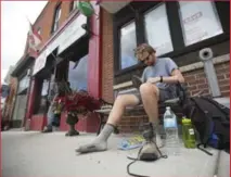  ?? PETER POWER FOR THE TORONTO STAR ?? Ballingall puts some inserts into his boots to soothe his aching feet at a pit stop in Cayuga, south of Hamilton.