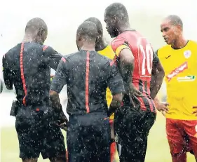  ??  ?? Referee Valdin Legister (left), and his assistant Richard Washington (second left), in discussion with Arnett Gardens captain Oneil Thompson (second right) and Wolry Wolfe, Humble Lion’s captain, during a Red Stripe Premier League game last season.