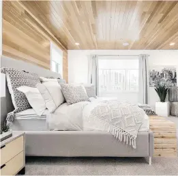  ??  ?? Light-toned woods, greys and black accents continue into the master bedroom, which has a stunning wood ceiling.