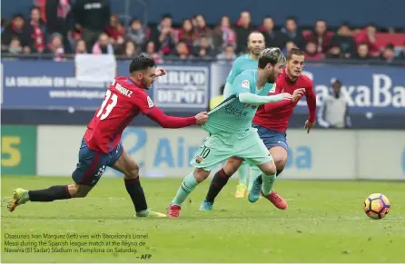  ?? — AFP ?? Osasuna’s Ivan Marquez (left) vies with Barcelona’s Lionel Messi during the Spanish league match at the Reyno de Navarra (El Sadar) Stadium in Pamplona on Saturday.