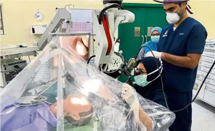  ??  ?? universiti Kebangsaan Malaysia Medical Centre (uKMMC) consultant EnT surgeon Prof dr Marina Mat Baki (sitting) conducting a surgical simulation to practise preventing aerosolisa­tion in an aGP for Covid-19 patients, assisted by this writer. — Photos: dr HaRdIP SInGH GEndEH