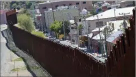  ?? MATT YORK — THE ASSOCIATED PRESS ?? The Internatio­nal border cuts through Nogales, Sonora, Mexico, right, and Nogales, Ariz., as seen Tuesday from Nogales, Ariz. The Republican governors of Texas, Arizona and New Mexico on Monday committed 1,600 Guard members to the border, giving...