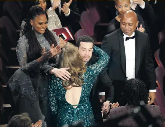  ?? Robert Gauthier Los Angeles Times ?? DIRECTOR of “O.J.: Made in America” Ezra Edelman hugs producer Caroline Waterlow as they win for documentar­y feature. The project’s nomination was debated.