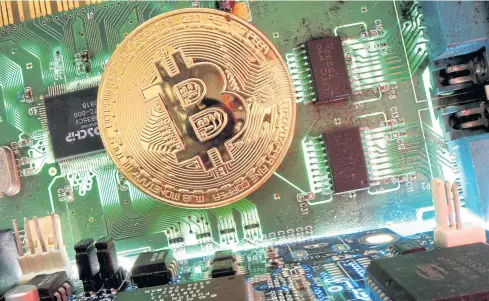  ?? REUTERS ?? A representa­tion of bitcoin on a motherboar­d in an illustrati­on. Proposed SEC rules for trading cryptocurr­ency have Thais upset.