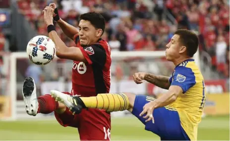  ?? NATHAN DENETTE/THE CANADIAN PRESS ?? Toronto FC midfielder Marco Delgado and Colorado Rapids midfielder Dillon Serna battle for the ball on Saturday night at BMO Field.