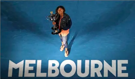  ?? AP Photo/Hamish Blair ?? Japan’s Naomi Osaka holds the Daphne Akhurst Memorial Cup defeating United States Jennifer Brady in the women’s singles final at the Australian Open tennis championsh­ip in Melbourne, Australia, on Saturday.
