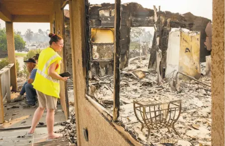  ?? Santiago Mejia / The Chronicle ?? Anna Noland looks over the rubble as James Nash sits with their daughter, Kailyn Nash, 16, at their Redding home.