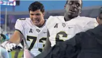  ?? COURTESY OF UCF ATHLETICS ?? UCF tackle Samuel Jackson, left, encourages teammates on Oct. 13.