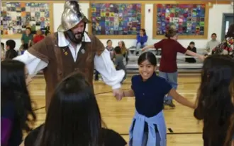  ?? MORGAN LEE, THE ASSOCIATED PRESS ?? Edwin Quintana, dressed as 17th century conquistad­or Don Diego de Vargas, dances with fifth grade students at Tesuque Elementary school in Tesuque, N.M.