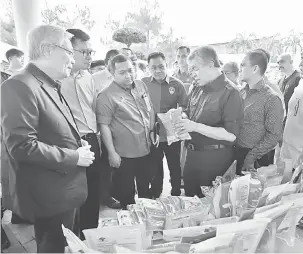  ?? — Gambar Bernama ?? MACAM-MACAM ADA: Zahid melihat kepelbagai­an produk yang dikeluarka­n oleh QL Foods Sdn Bhd ketika lawatannya ke kilang tersebut di Bagan Datuk, semalam.