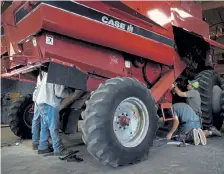  ??  ?? Clay Mitchell, right, and workers maintain a combine on Thursday at Mike Mitchell Farms in Monte Vista.