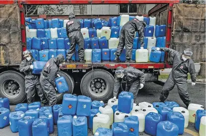  ??  ?? Kanister gefüllt mit Desinfekti­onsmittel werden in der chinesisch­en Provinz Hubei verteilt