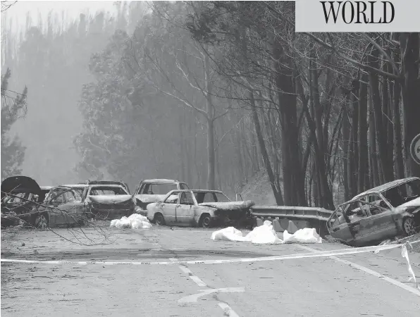  ?? ARMANDO FRANCA / THE ASSOCIATED PRESS ?? Burned-out cars line the road between Castanheir­a de Pera and Figueiro dos Vinhos, central Portugal, on Sunday after flames swept over the area, killing scores of people.