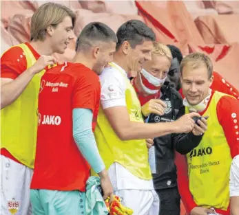  ?? FOTO: HEIKO BECKER/IMAGO IMAGES ?? Der Moment, als der VfB Stuttgart begriff, dass er aufgestieg­en ist: VfB-Sprecher Tobias Herwerth zeigt den Ersatzspie­lern um Mario Gomez (links daneben) und Holger Badstuber (re.) das Ergebnis aus Heidenheim.