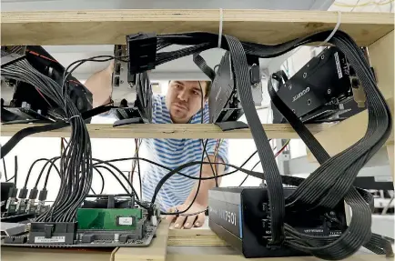  ?? PHOTO: GETTY IMAGES ?? A technician works on hardware at the Sberbit cryptocurr­ency mining equipment facility.