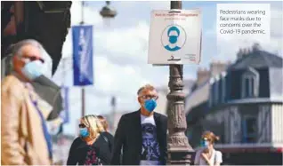  ??  ?? Pedestrian­s wearing face masks due to concerns over the Covid-19 pandemic.