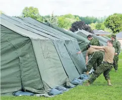  ?? GRAHAM HUGHES FOR NATIONAL POST FILES ?? Members of the Canadian armed forces set up tents to house asylum seekers in Cornwall, Ont., last summer.