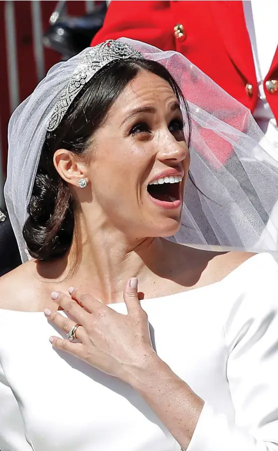  ??  ?? her chest in awe – as the new Duke and Duchess of Sussex are greeted by well-wishers who packed the streets of Windsor for sealed their union with a kiss at the top of the steps of St George’s Chapel, to screams and applause from members of the public