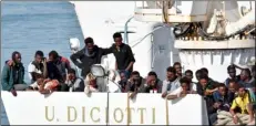  ??  ?? Migrants wait to disembark from an Italian Coast Guard vessell “Diciotti” as it docks at the Sicilian port of Catania, southern Italy, Wednesday. orIeTTA sCArdIno/AnsA VIA AP