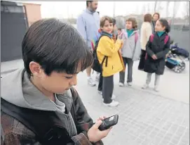  ?? MANÉ ESPINOSA ?? Un estudiante de primaria con un teléfono móvil