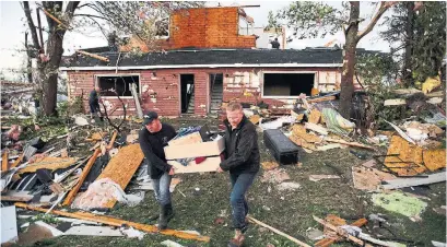  ?? SEAN KILPATRICK THE CANADIAN PRESS PHOTOS ?? Residents of Dunrobin, Ont., west of Ottawa, salvage items from a damaged home after a tornado touched down on Friday.