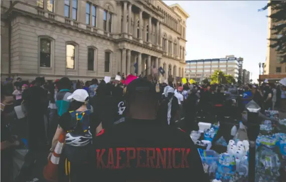  ?? BRETT CARLSEN/GETTY IMAGES ?? A view of a protester’s Colin Kaepernick jersey as he and others gather outside city hall on Friday in Louisville, Ky., to protest the killing of George Floyd.