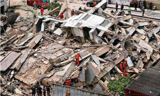  ?? Fabio Lima/O Povo/Folhapress ?? Bombeiros buscam vítimas do desabament­o; além do edifício, veículos e um estabeleci­mento comercial foram atingidos pelos escombros