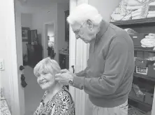  ?? SHELLEY MAYS, THE TENNESSEAN ?? Clifford Smith helps his wife, Wilma, put on her earrings. They have been married for 62 years.