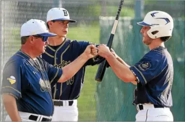  ?? PETE BANNAN-DIGITAL FIRST MEDIA ?? Exton manager Jim Turner and Grayson Davis congratula­te Jackson Rithhamel after he scored in the Bandit’s victory 16-0.