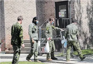  ?? RICHARD LAUTENS TORONTO STAR FILE PHOTO ?? Military personnel are seen changing shifts behind the Eatonville Care Centre on May 26. The long-term-care centre is among the facilities in Toronto with 40 or more COVID-19 deaths.