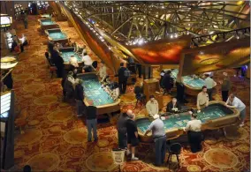  ?? JESSICA HILL- ASSOCIATED PRESS FILE ?? In this Sept. 18, 2013file photo, patrons play craps at tables at Mohegan Sun in Uncasville, Conn. The shutdown of the Mohegan Sun and Foxwoods casinos for the pandemic has contribute­d to soaring unemployme­nt in eastern Connecticu­t, a region that has seen some of the biggest spikes in jobless numbers despite relatively few infections.