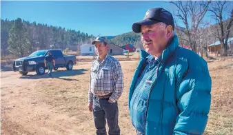  ?? EDDIE MOORE/ ALBUQUERQU­E JOURNAL ?? Joe Chavez, left, and Donald Laran talk to a Journal crew in December after a sheriff’s deputy, in background, asked them to get off a small tract that has been part of a property dispute involving the Archdioces­e of Santa Fe in the Mora County village...