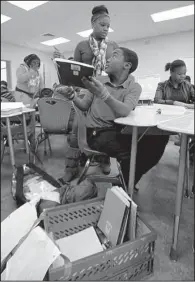  ?? Arkansas Democrat-Gazette/STEPHEN B. THORNTON ?? Amboy Elementary School fifth-grade teacher Valencia Rochelle helps student Curtis Marshall decide earlier this month what to put into his desk at the new school building.