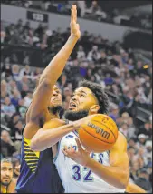  ?? Bruce Kluckhohn The Associated Press ?? Timberwolv­es forward Karl-anthony Towns eyes the basket against Pacers center Myles Turner in Minnesota’s 127-109 win Saturday at Target Center.